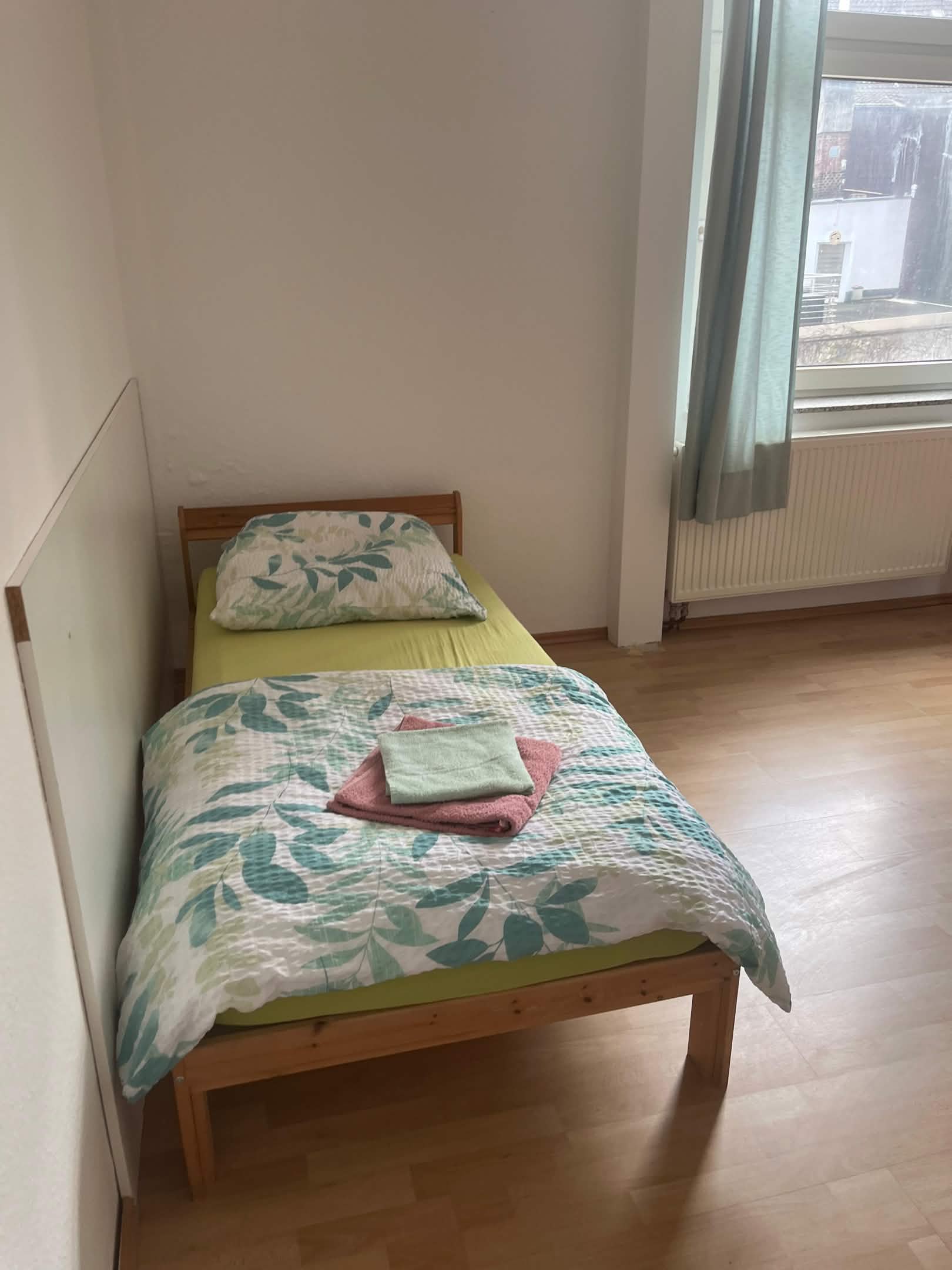 Einzelbett mit Bettwäsche